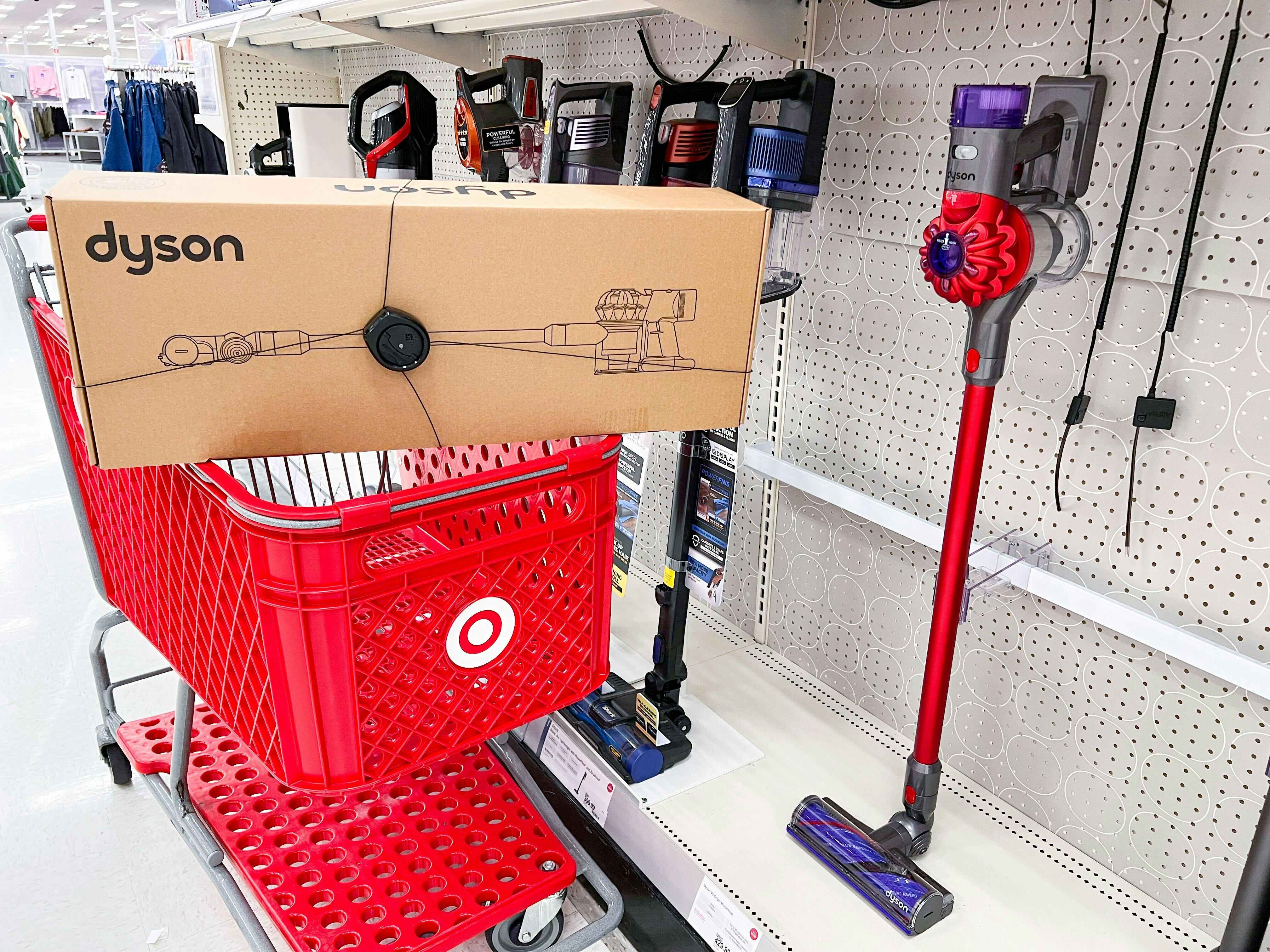 A Dyson vacuum in a Target shopping cart parked next to a display.