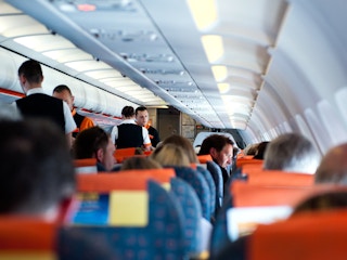flight attendants and passengers in airplane cabin
