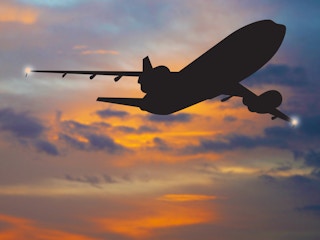 airplane silhouette flying at sunrise or sunset
