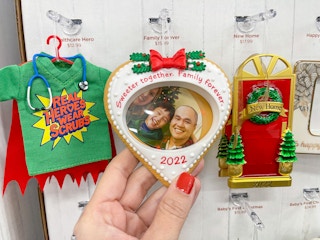 A Hallmark ornament held while hanging from display