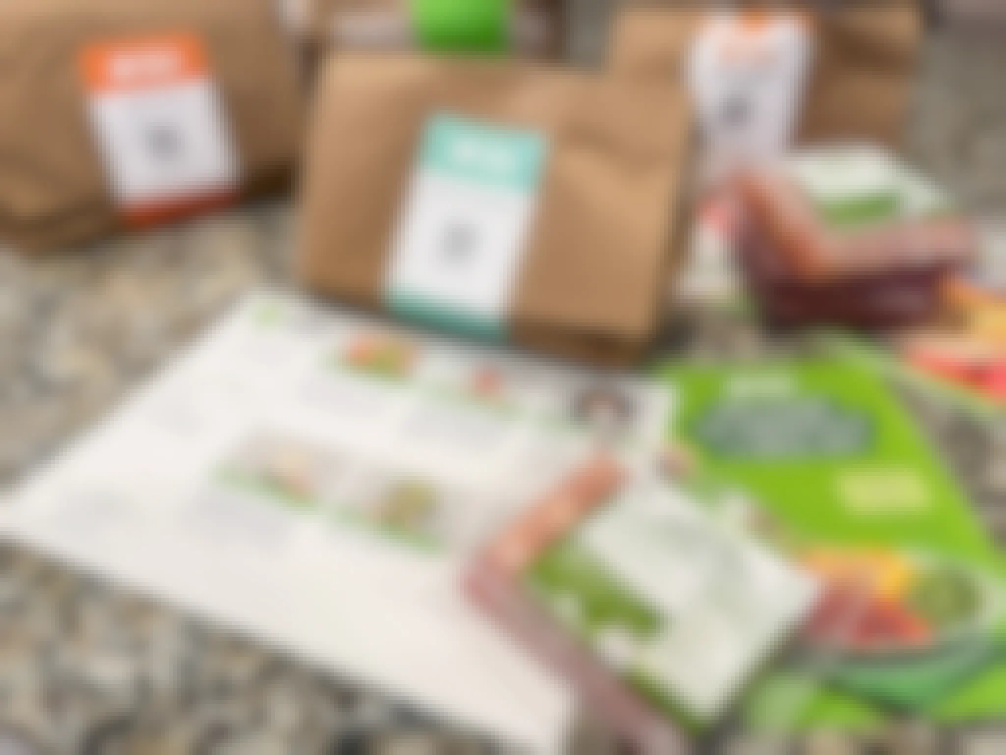Hello Fresh meal bags, packaged meat, and recipe cards on a counter.