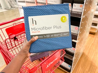 someone holding a microfiber sheet set