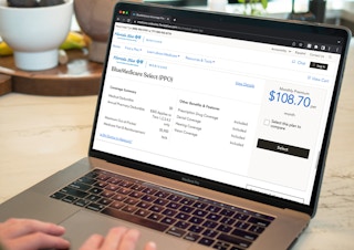 A person using a laptop displaying a Florida Blue medicare plan on their website.