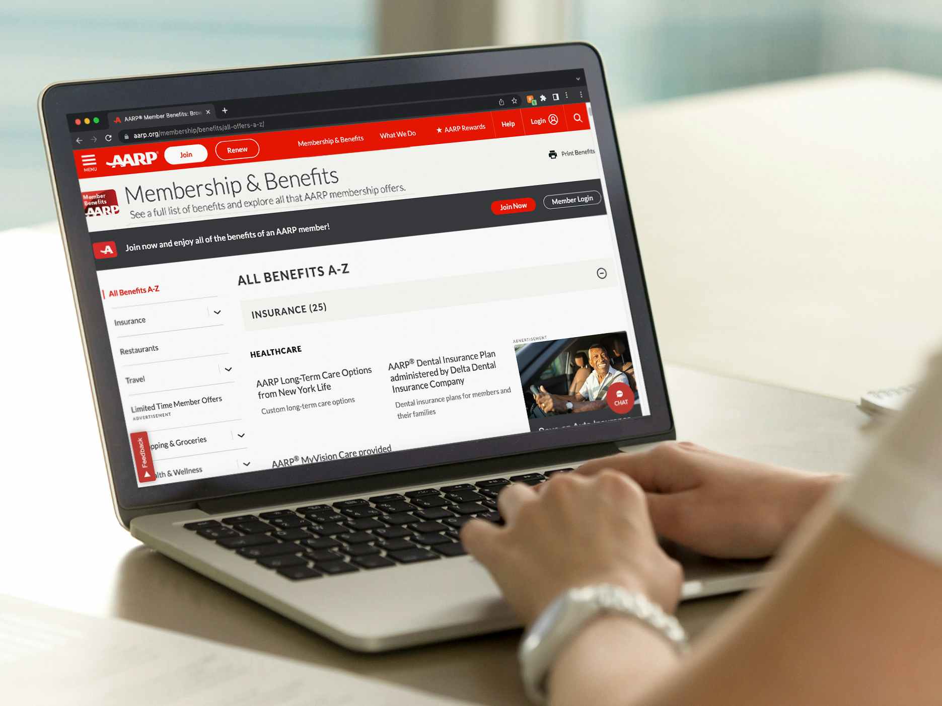 A person using a laptop displaying the AARP website's Member Benefits