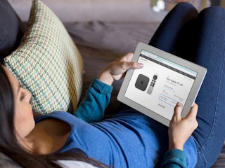 person on couch at home shopping for apple tv on ipad