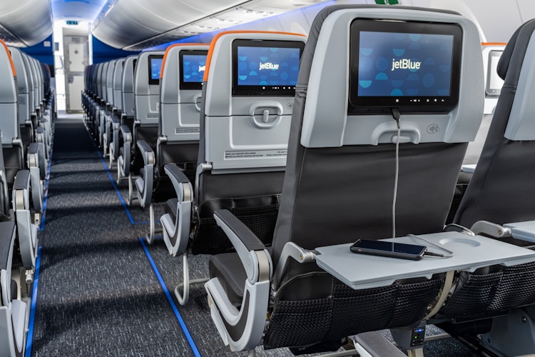 jetblue a2220 plane seats with screens on saying jetblue and phone charging