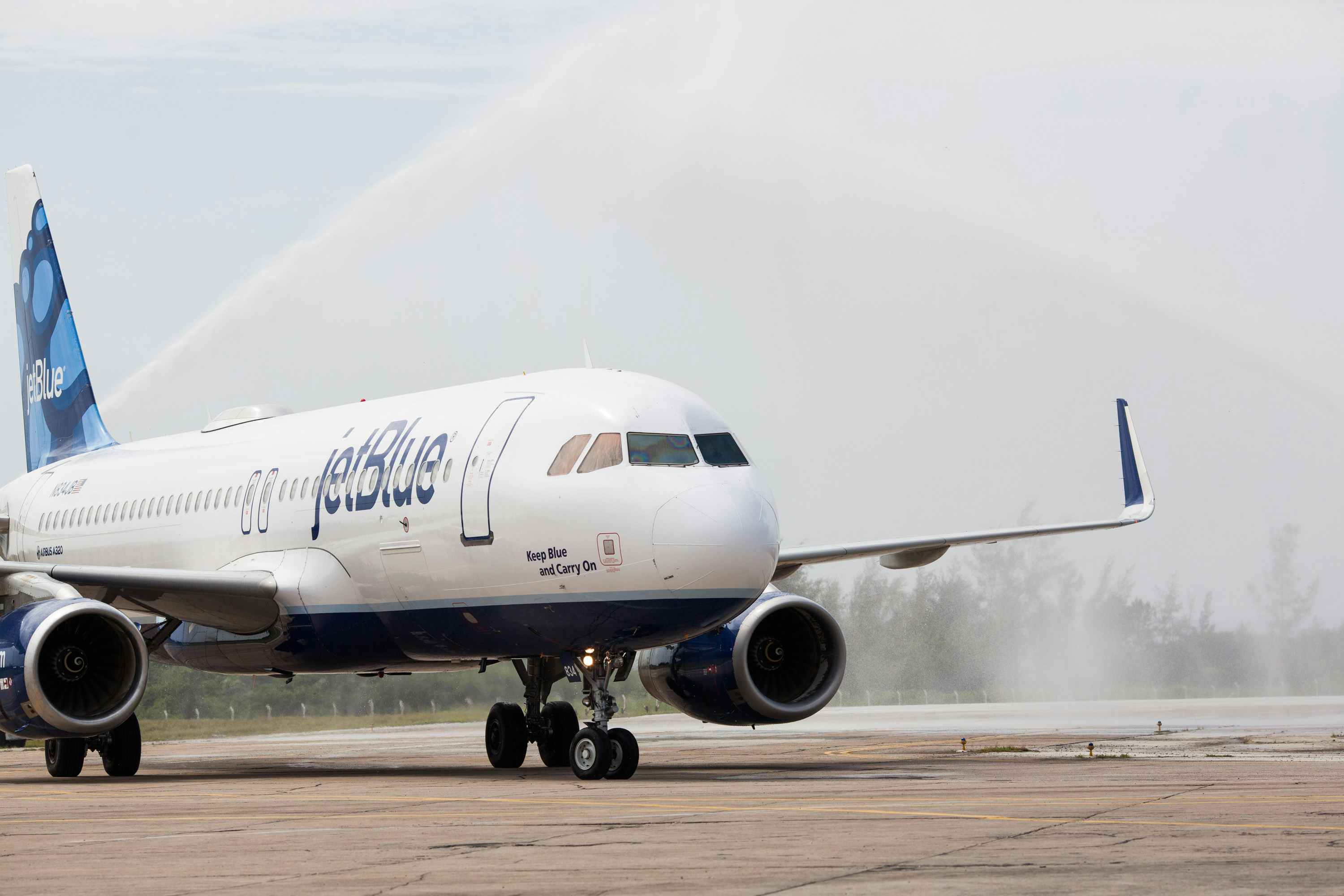 image of jetblue plane landing on runway