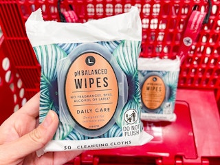 hand holding feminine wipes above cart