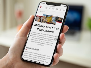 A person holding a phone displaying the information for the Lululemon military and first responders discount