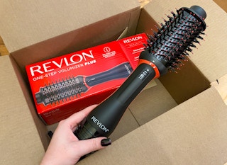 hand holding a revlon one step volumizer plus over a box