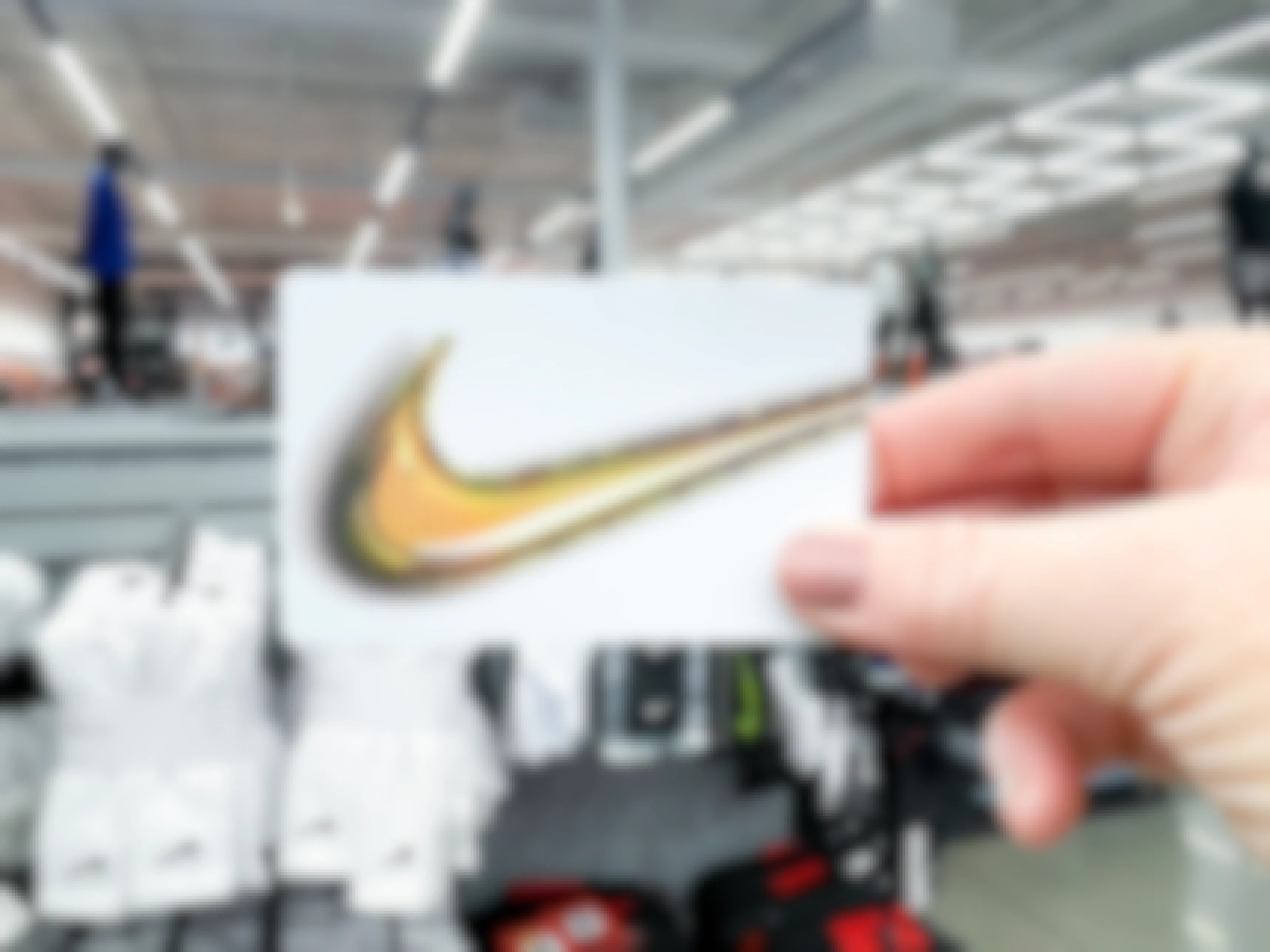 Someone holding up a Nike gift card inside a Nike store.