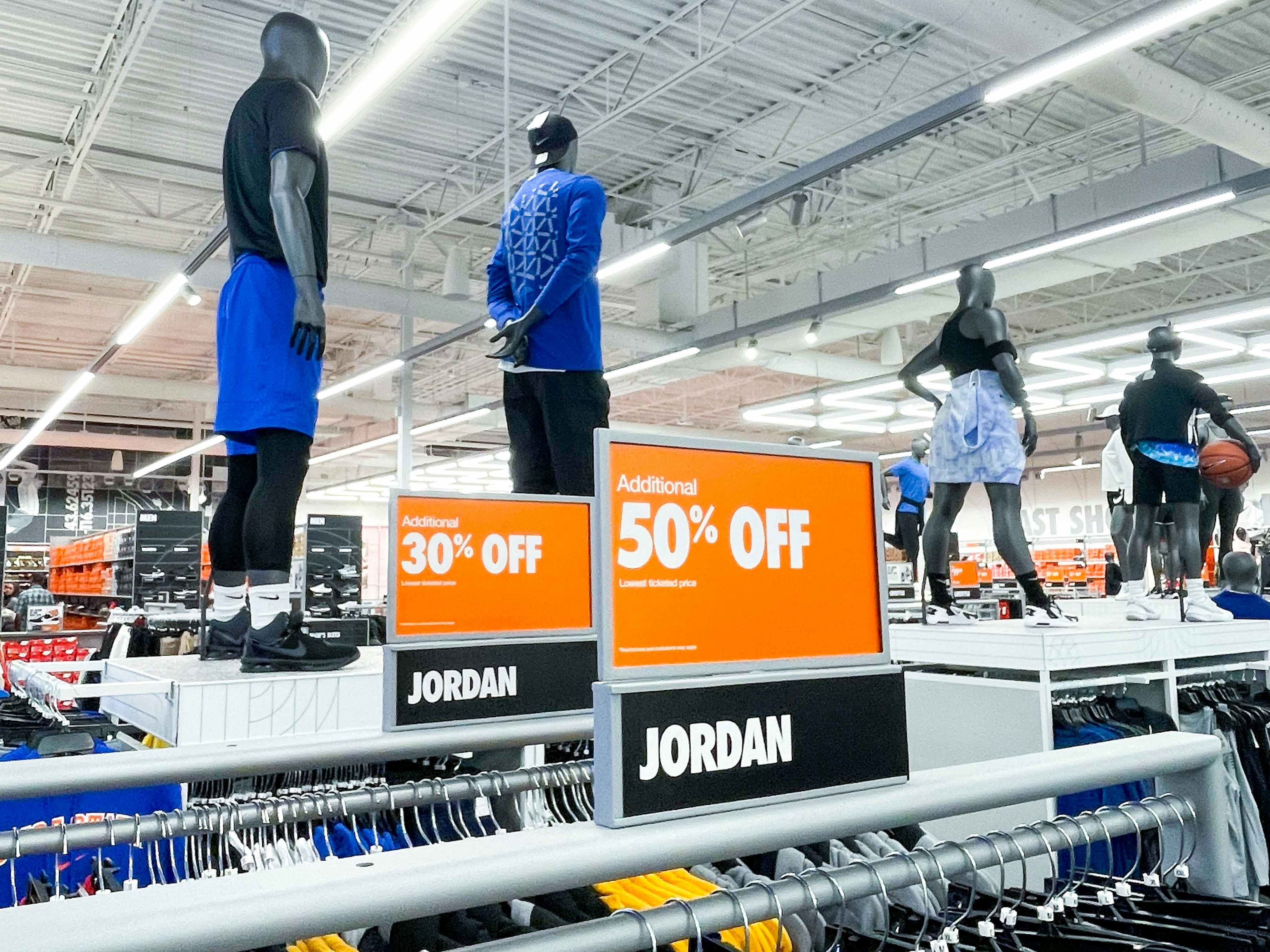 Sale signs affixed to clothing racks of Jordan brand athletic wear in a Nike store