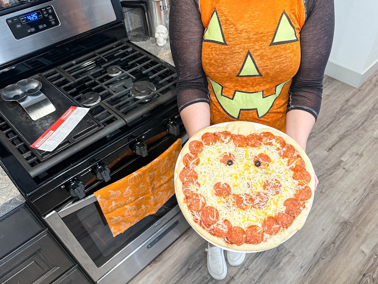 a person holding a papa murphys halloween pizza