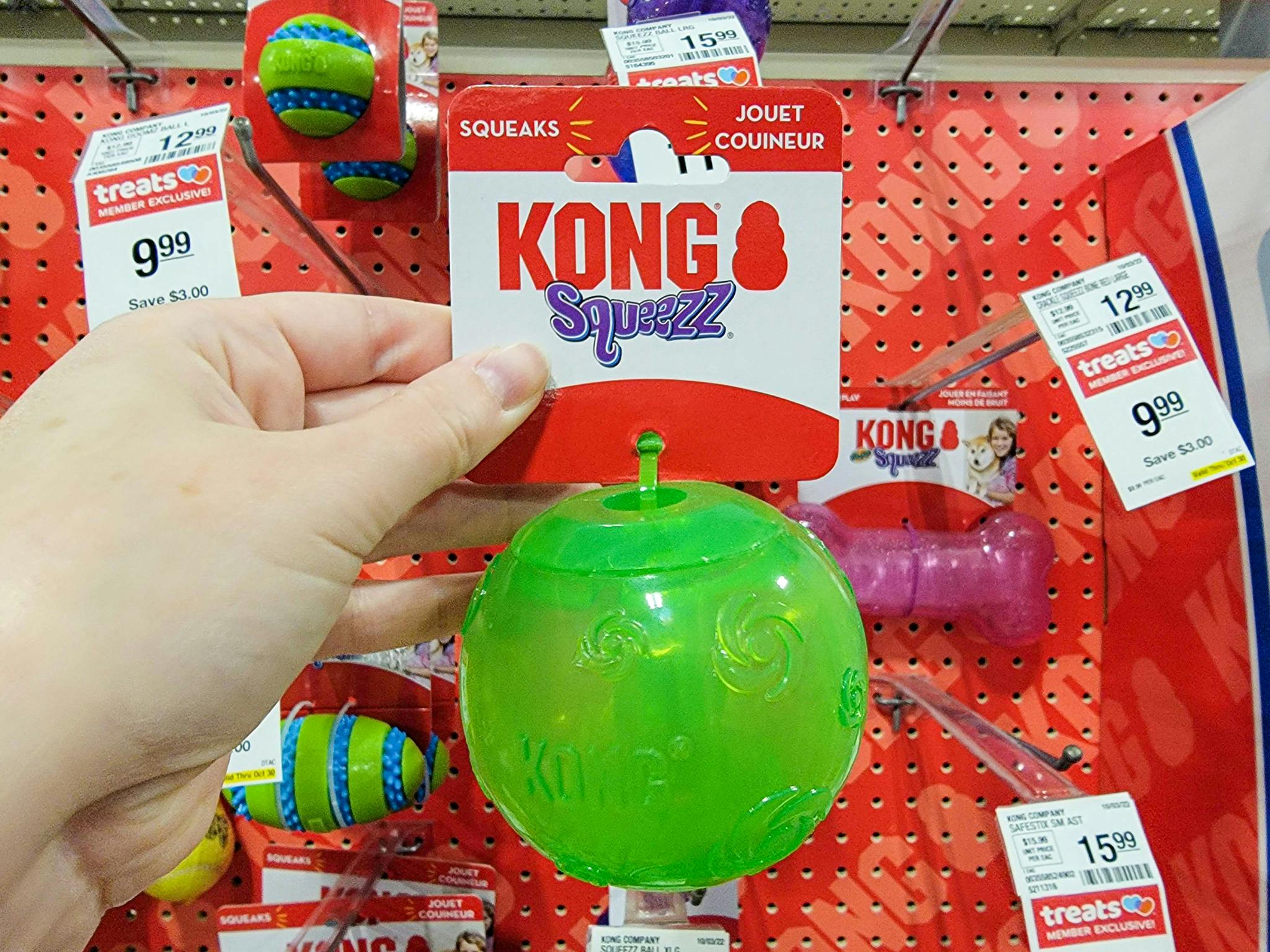 hand holding a green kong dog toy ball