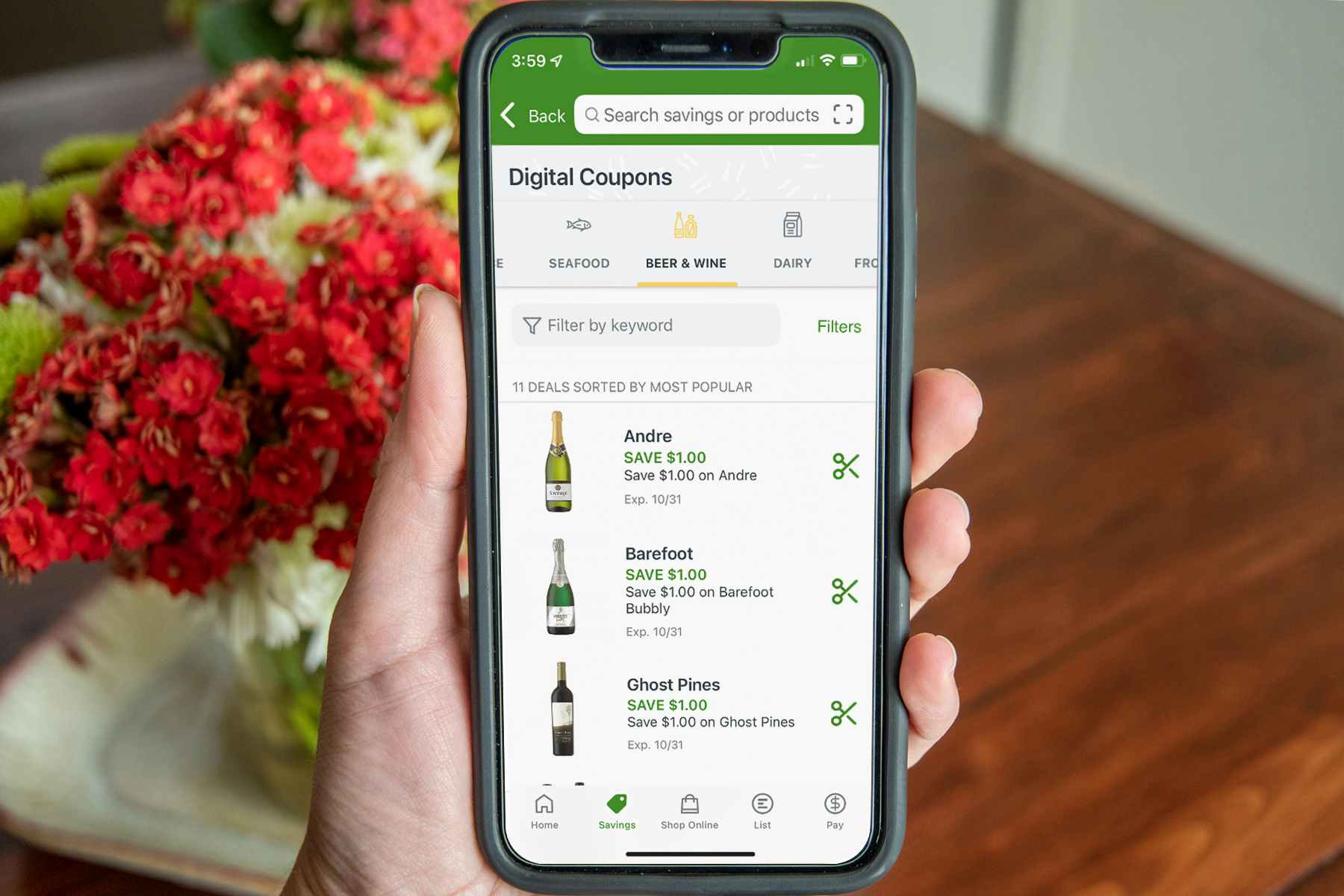 A person holding a phone displaying Publix coupons in their app