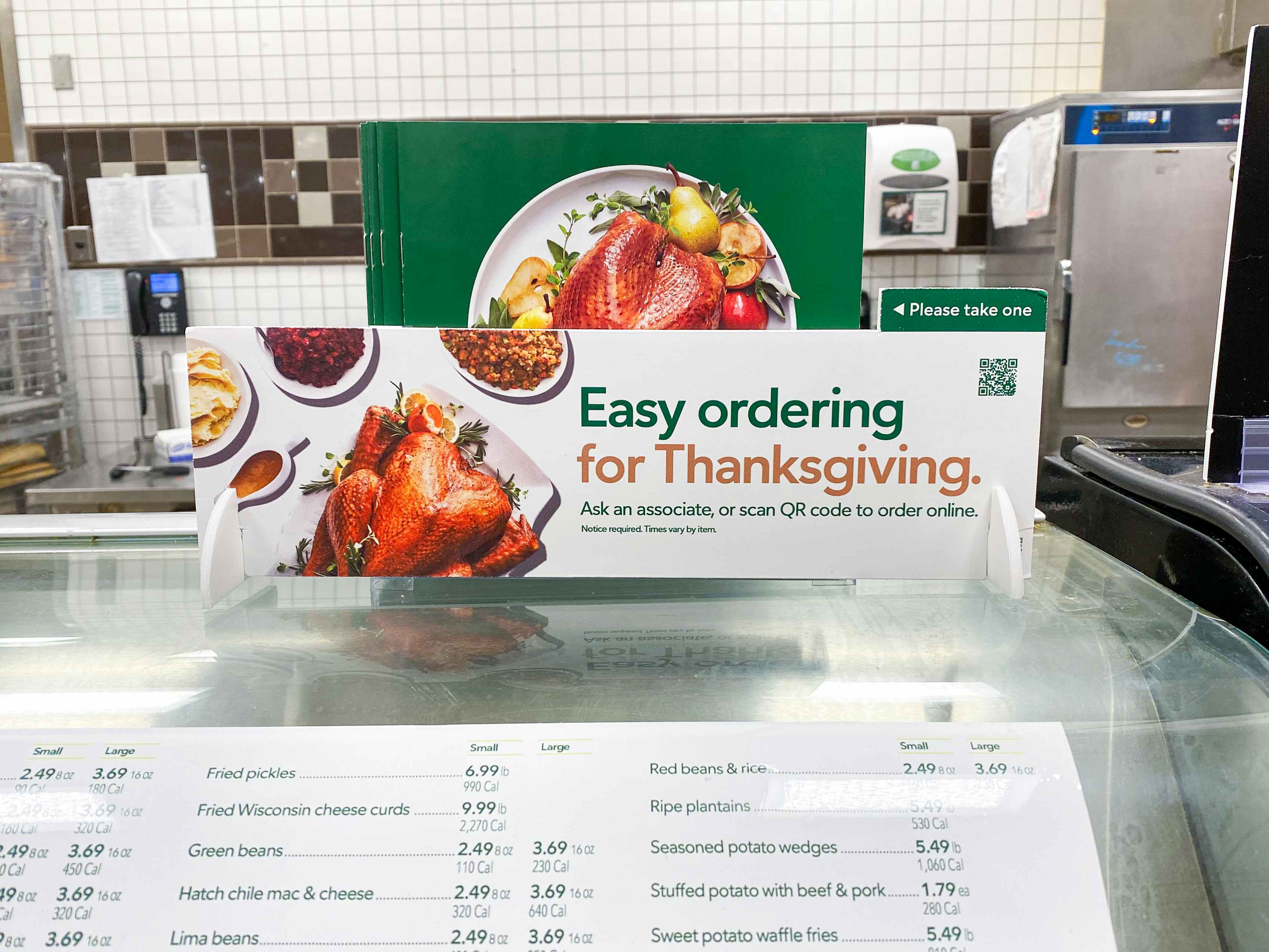 A sign in the Publix Deli that says, "Easy ordering for Thanksgiving" with some booklets to take.