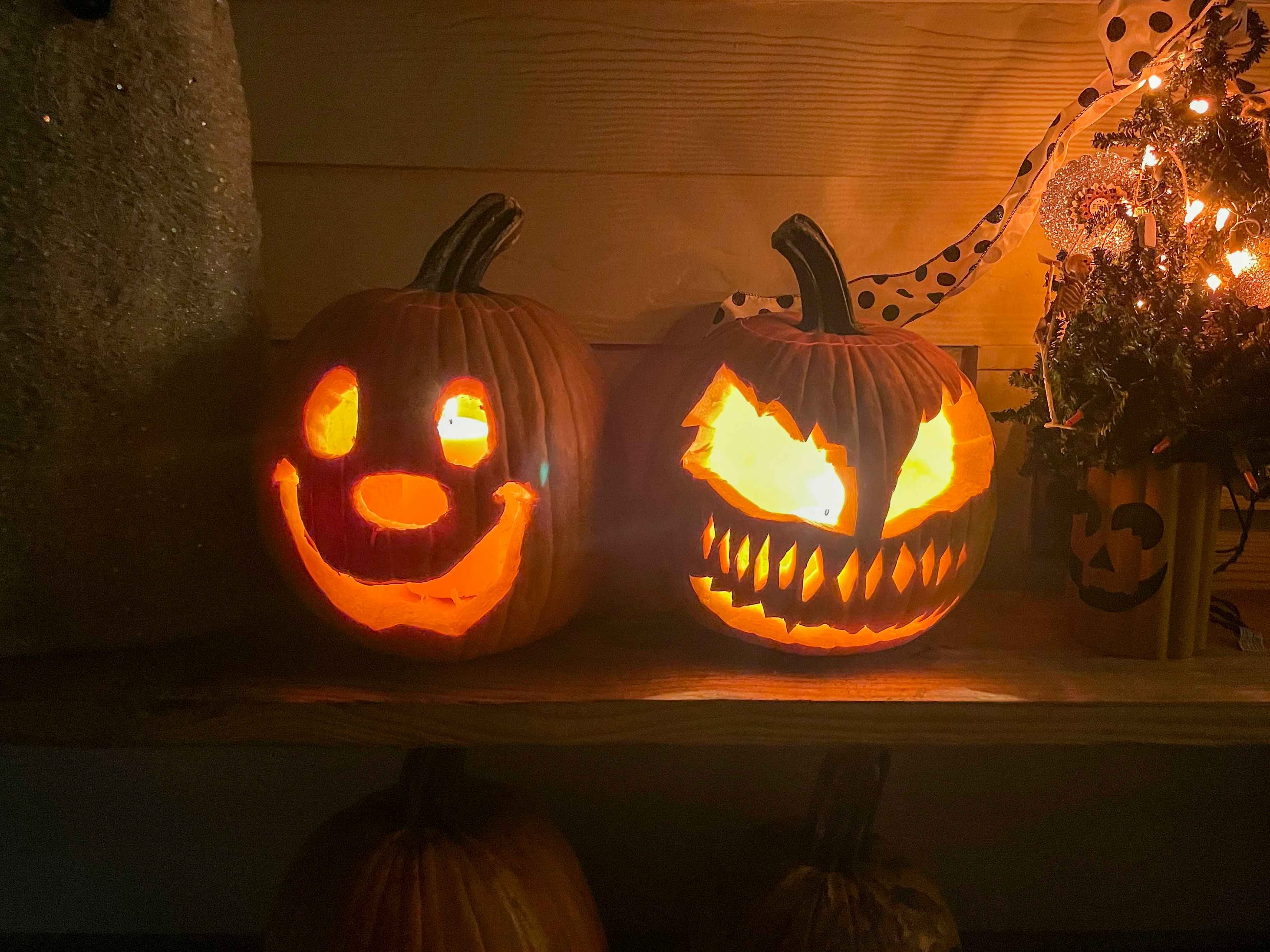 two carved pumpkins lit from inside.