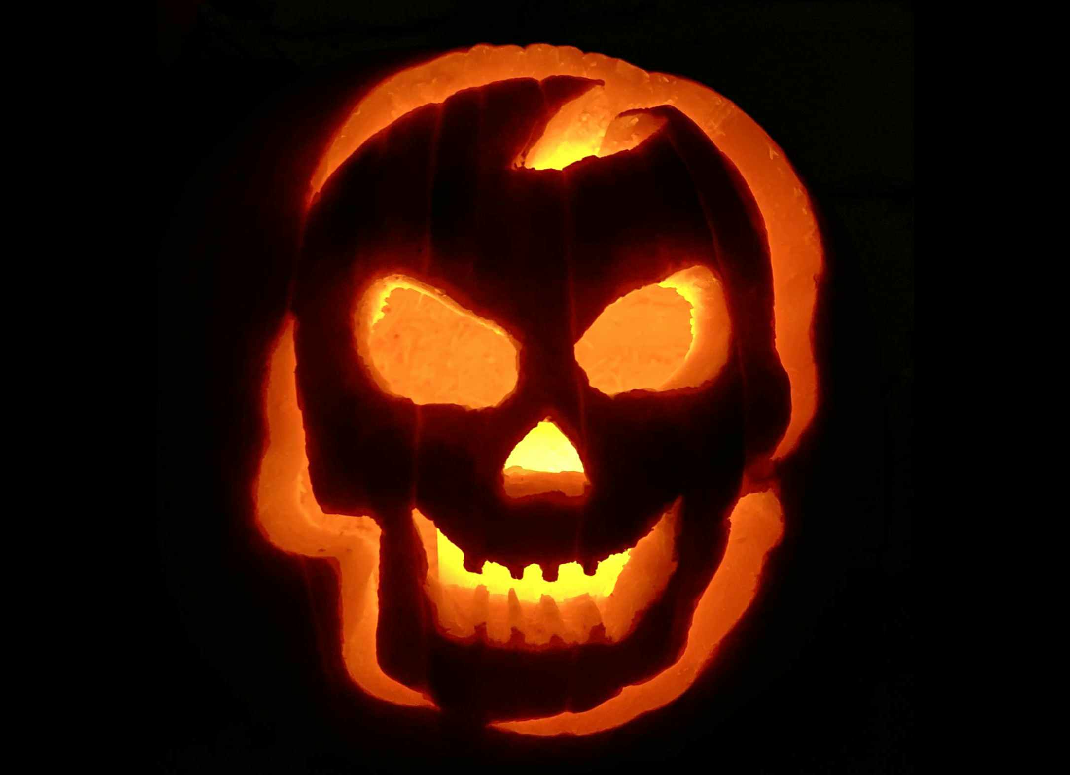 Pumpkin carved with a skull on the front.