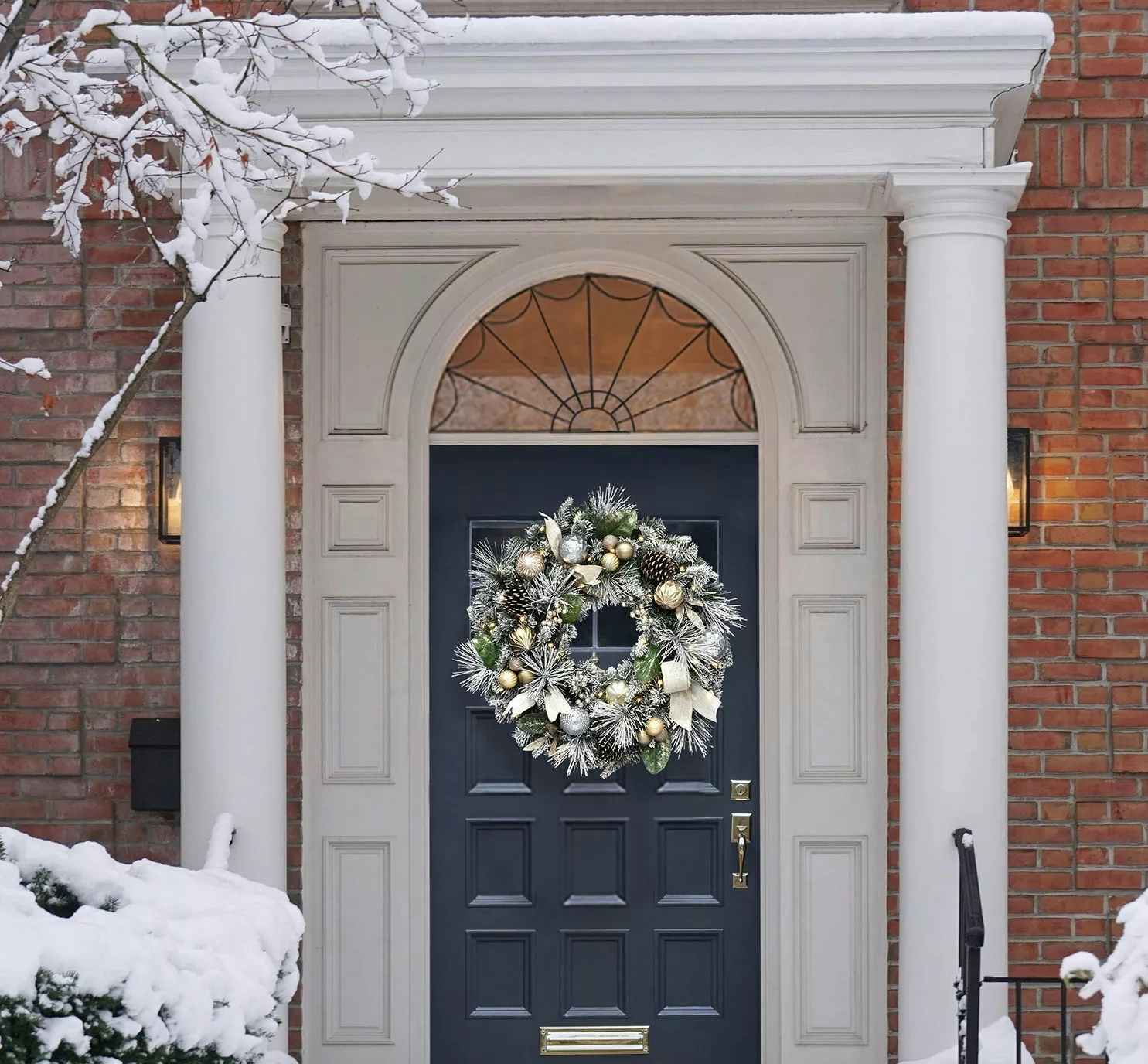 holiday pre lit wreath hanging on a front door