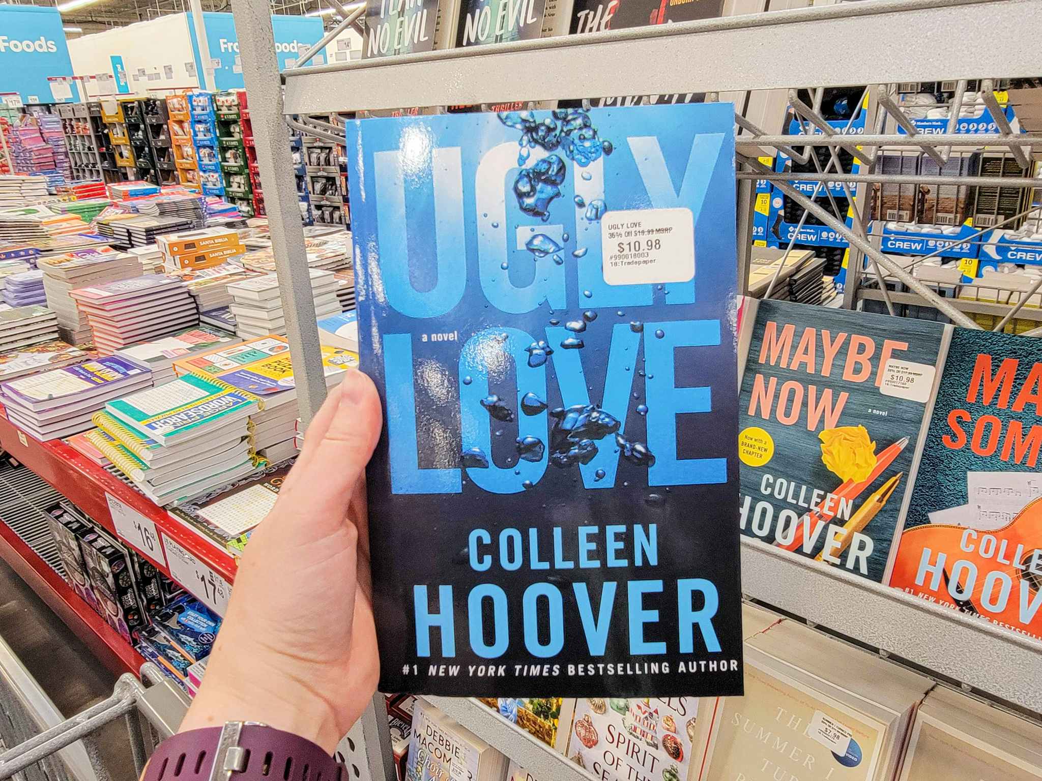 hand holding "ugly love" by colleen hoover
