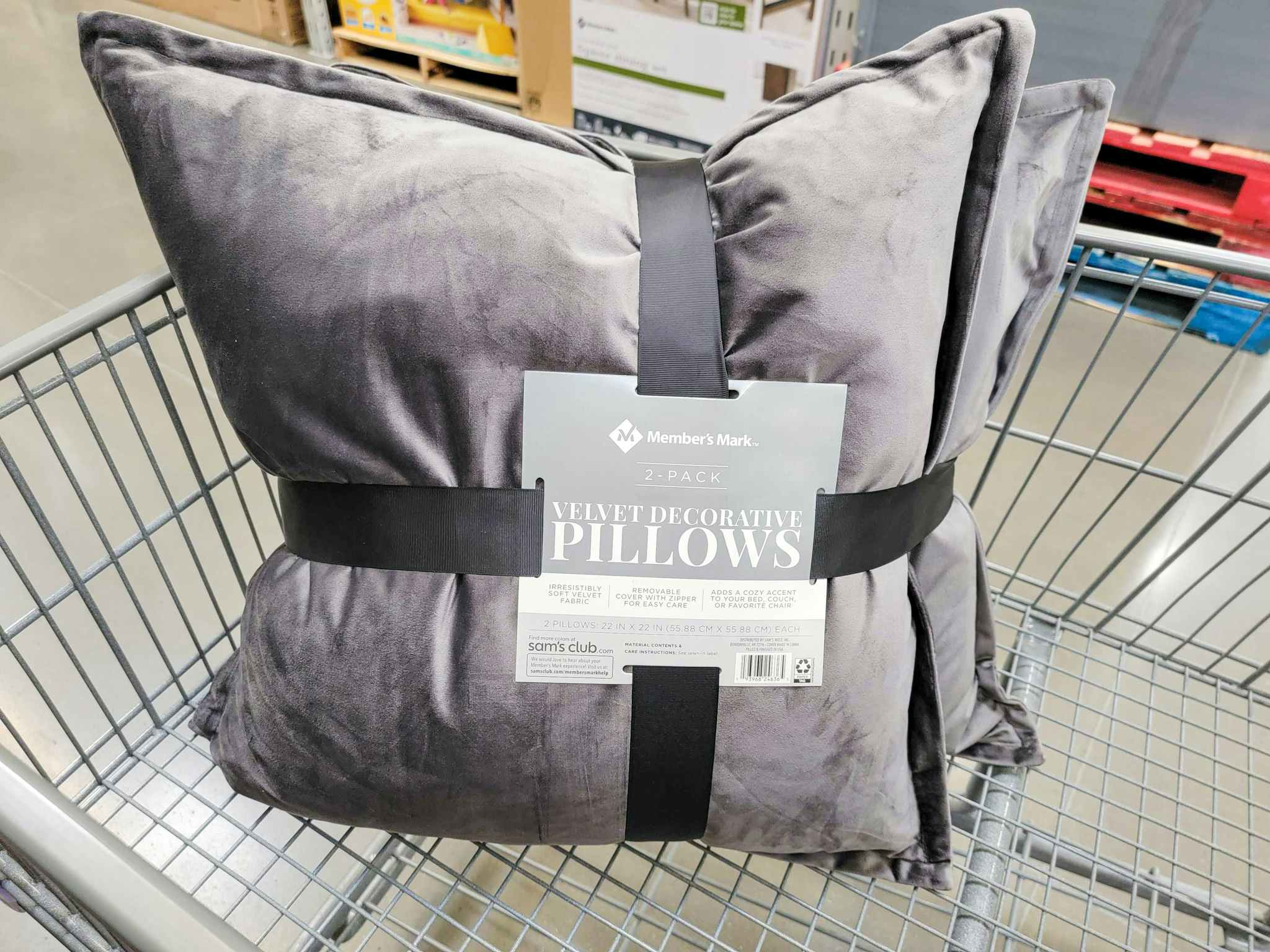 a 2 pack of grey velvet pillows in a cart