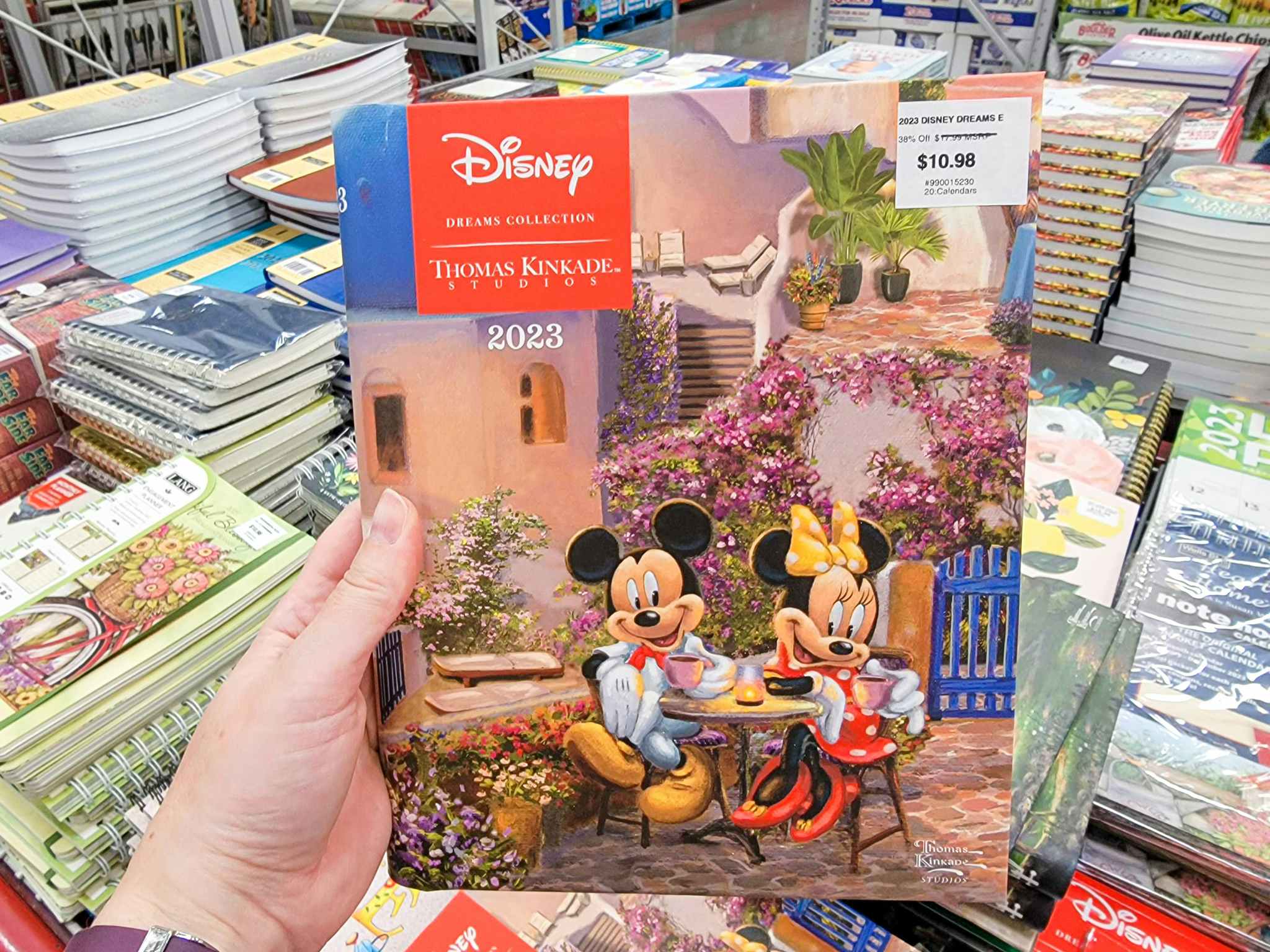 hand holding a disney thomas kinkade 2023 planner