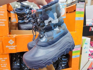 hand holding a pair of dark blue camo kids snow boots