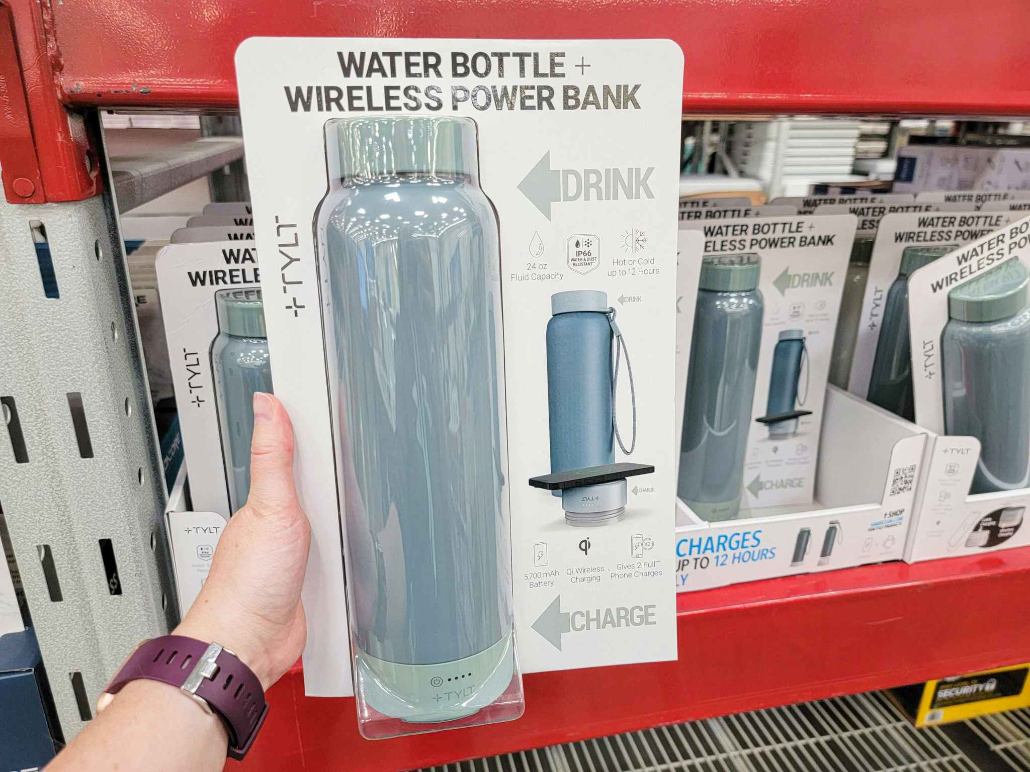 hand holding a blue water bottle/ wireless power bank combo