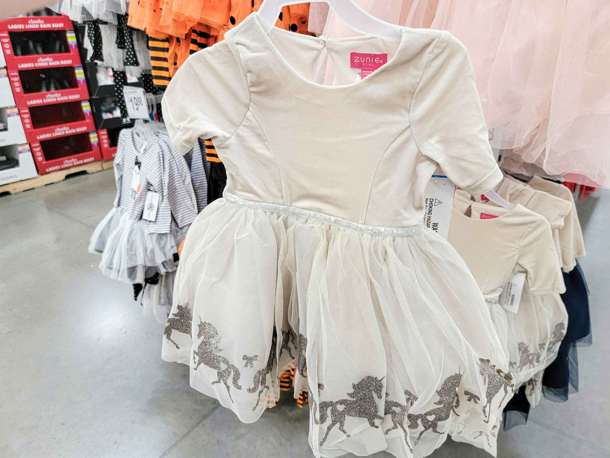 a cream kids dress with glitter unicorns along the bottom