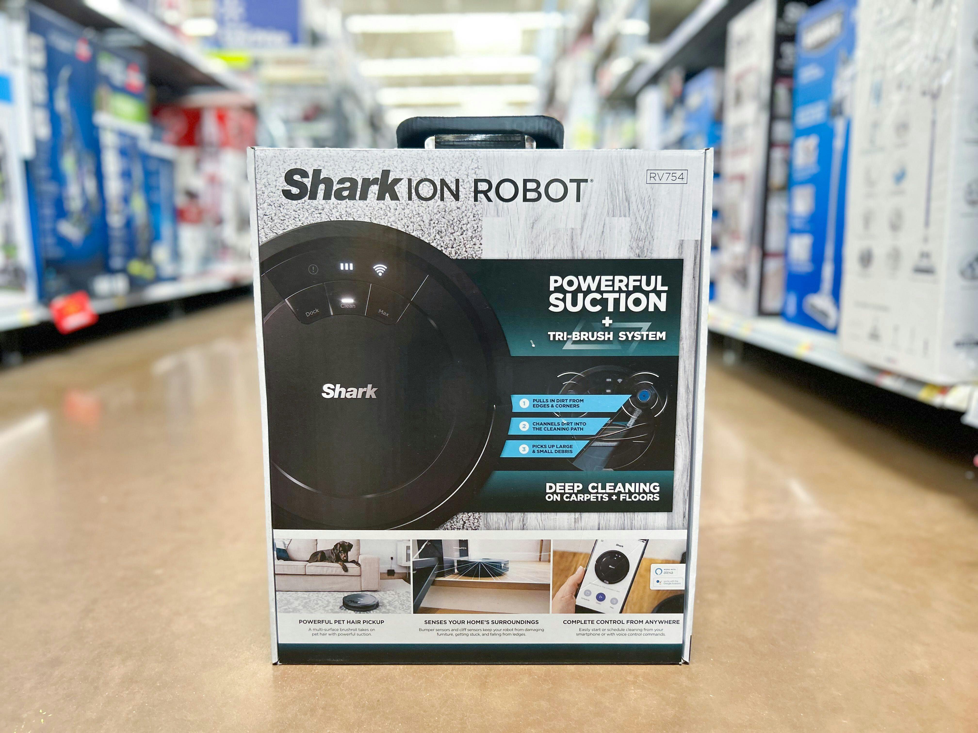 A Shark ion Robot vacuum box on the floor in the vacuum aisle of a store.