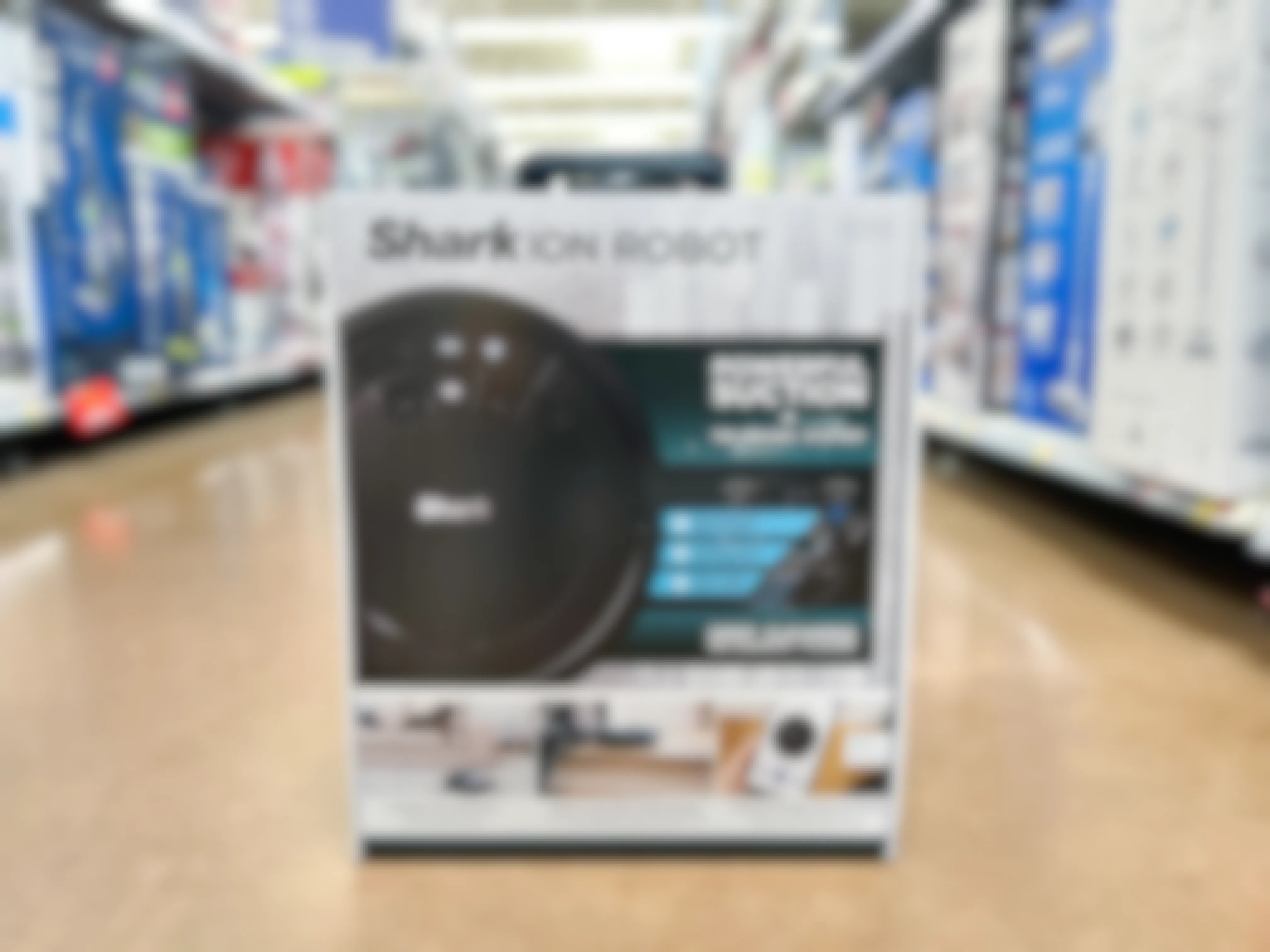 A Shark ion Robot vacuum box on the floor in the vacuum aisle of a store.