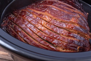 a cooked ham inside a slow cooker
