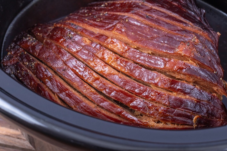 a cooked ham inside a slow cooker 