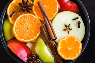 a slow cooker filled with fruit and spiced apple cider.