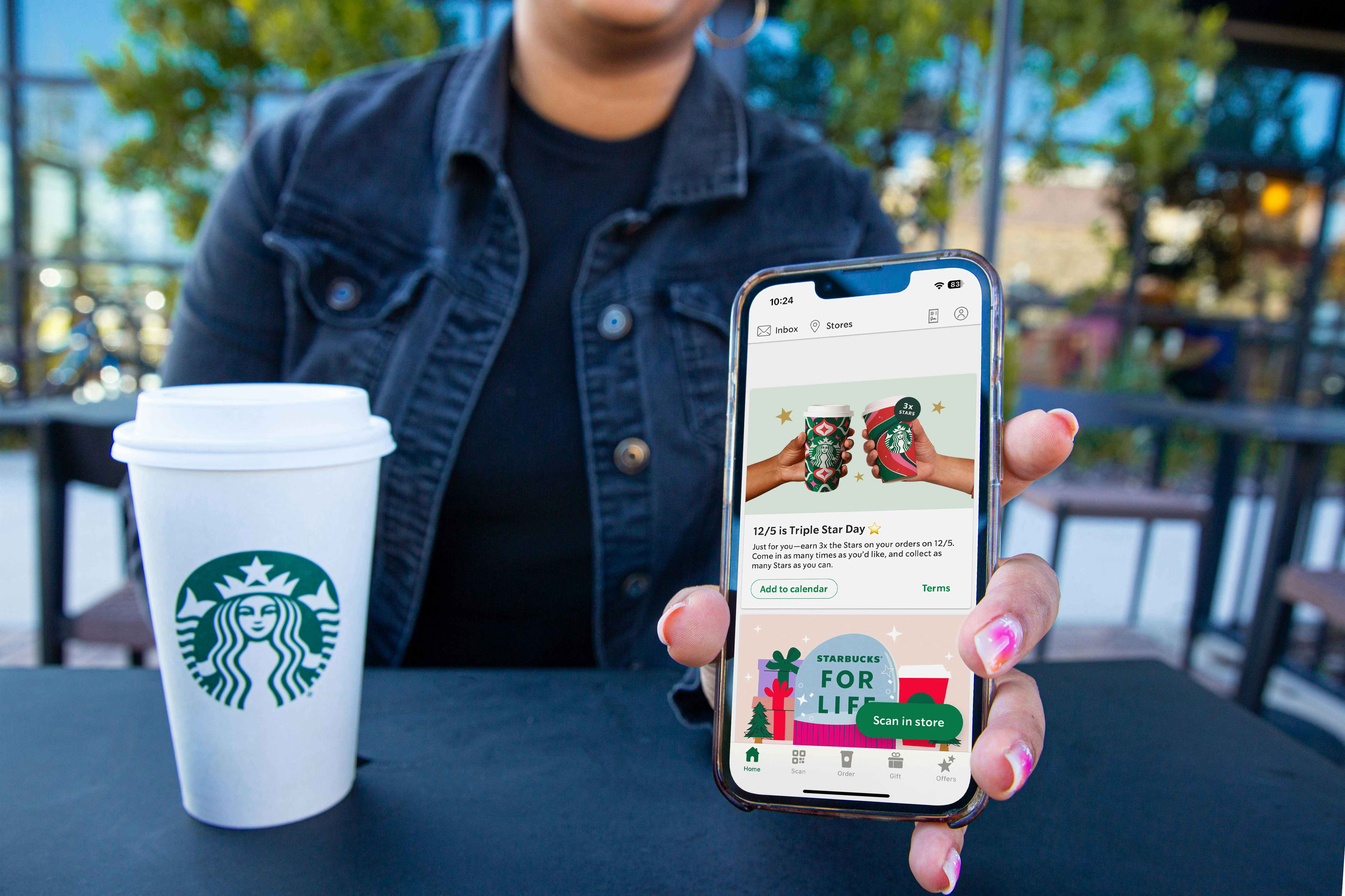Person holding their phone showing the starbucks app