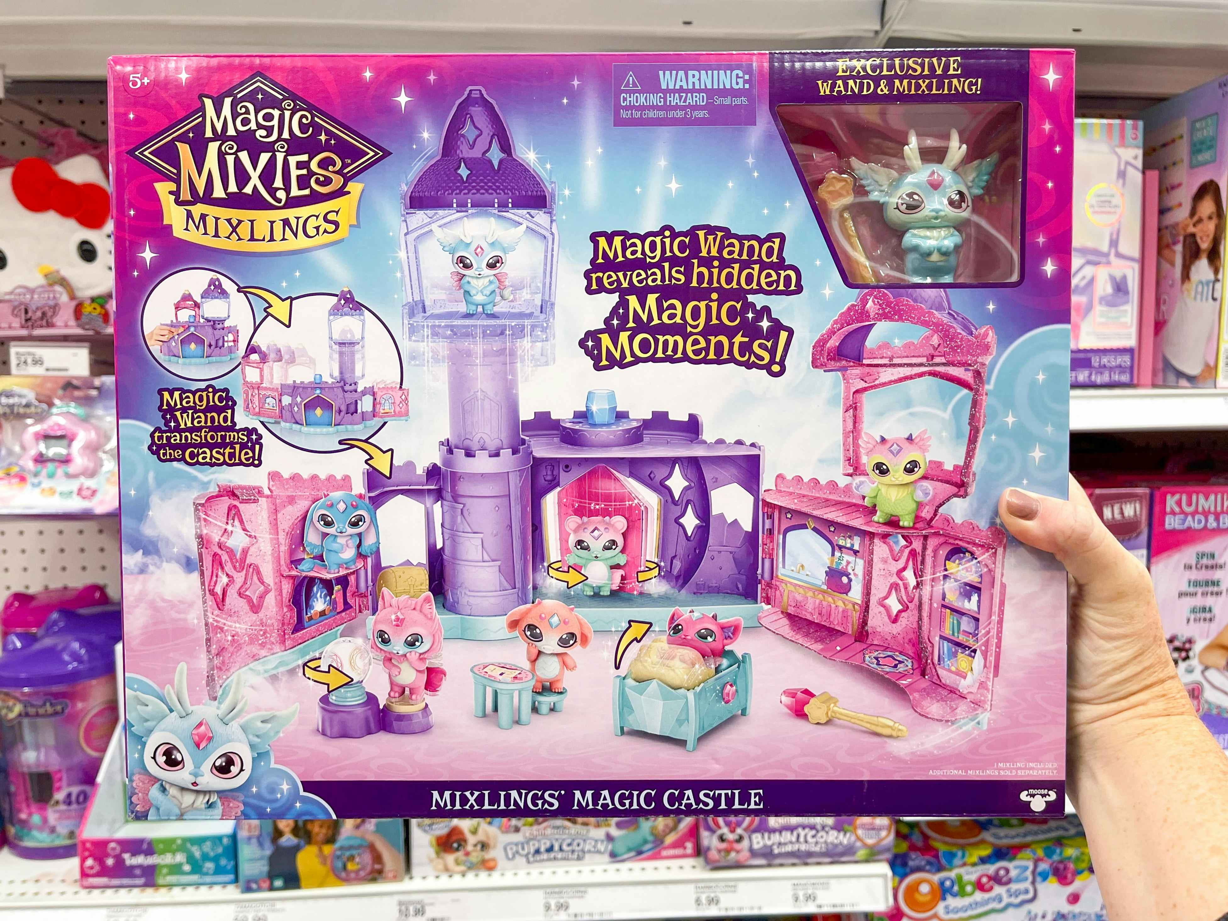 A person holding up a Magic Mixies Mixlings Castle Playset in Target.