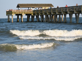 people on a wooden pier over the ocean