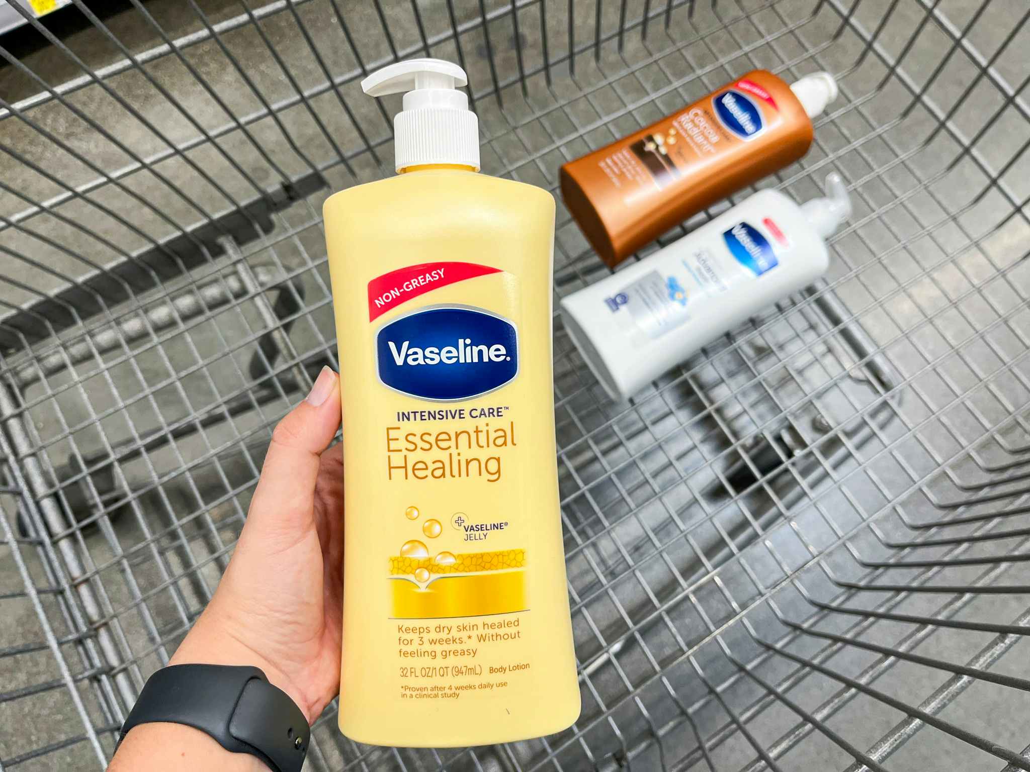 hand holding up Vaseline lotion over the top of a Walmart shopping cart