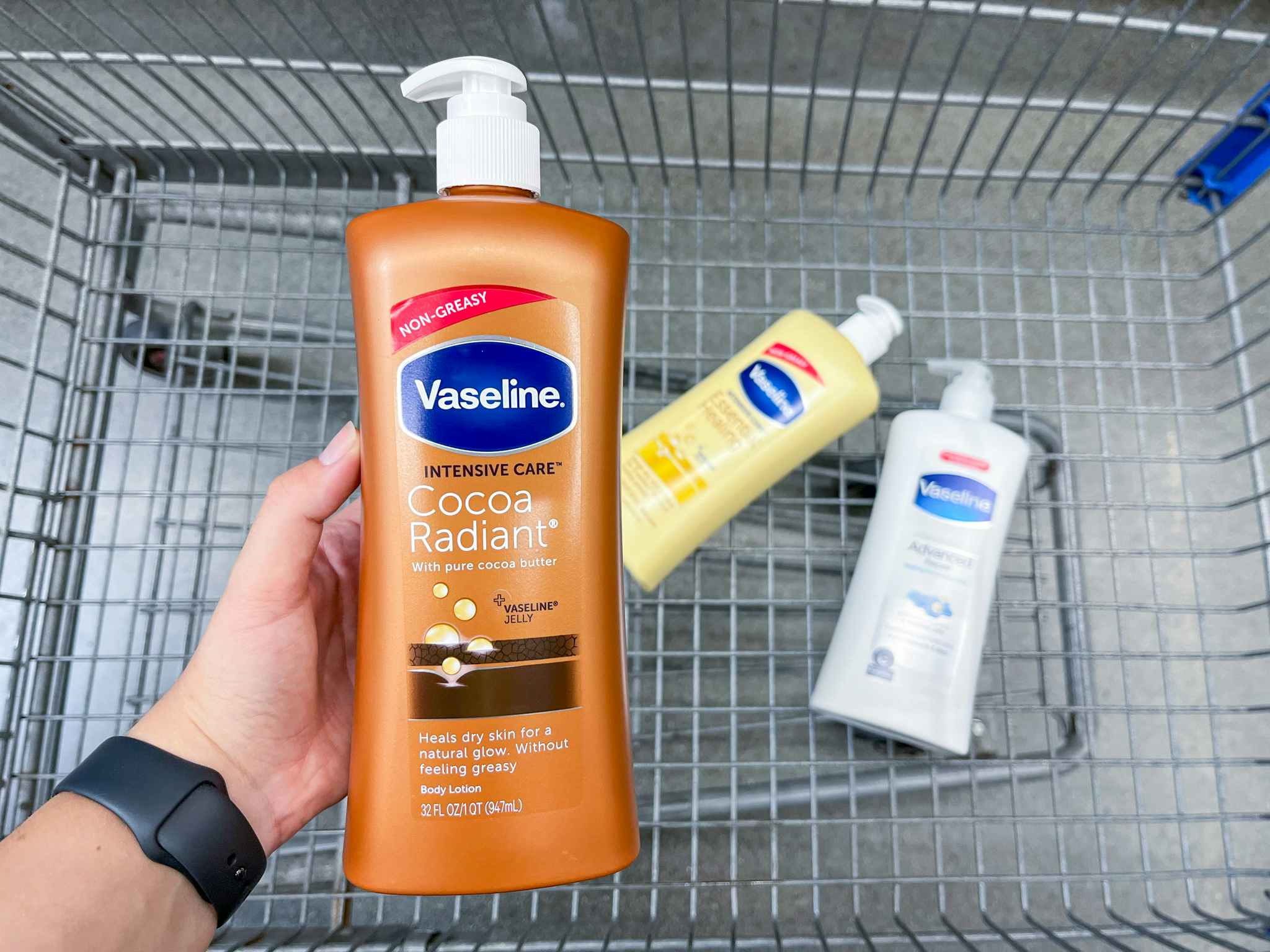 hand holding up Vaseline lotion over the top of a Walmart shopping cart