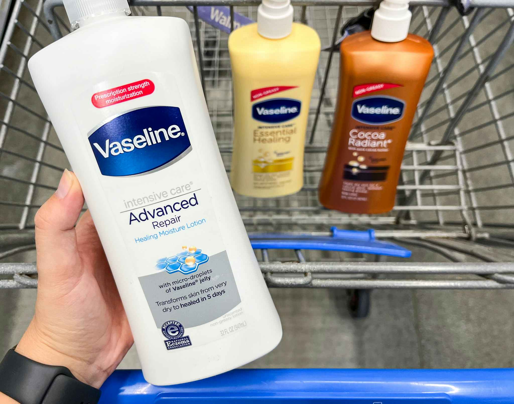 hand holding up Vaseline lotion over the top of a Walmart shopping cart