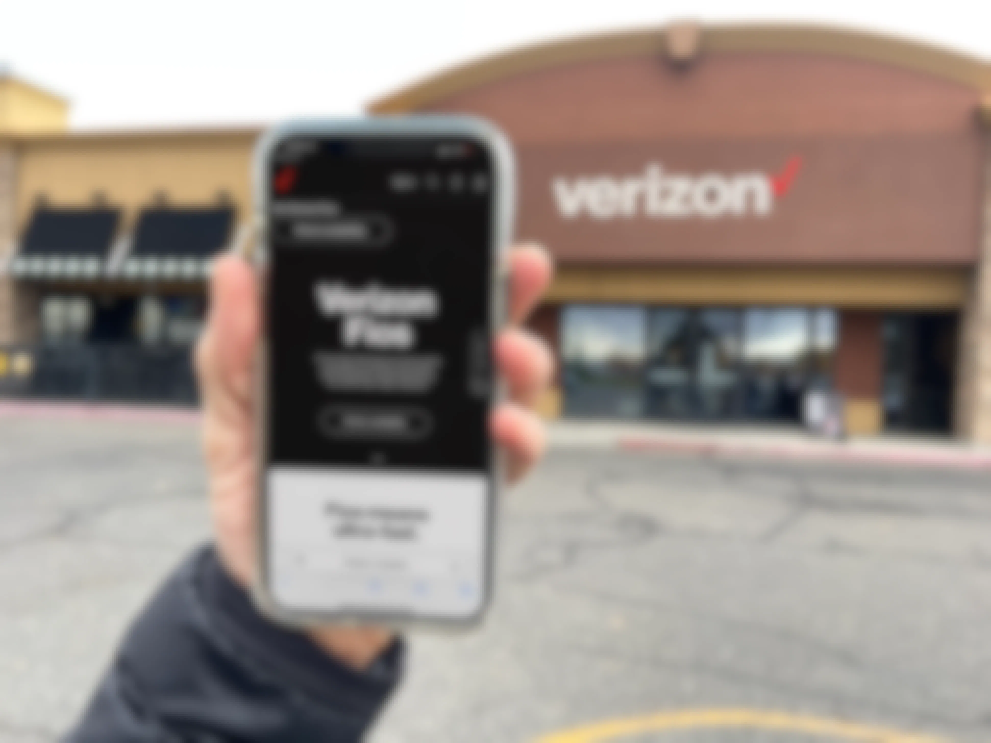 a hand holding a cellphone in front of verizon with verizon app fios on screen