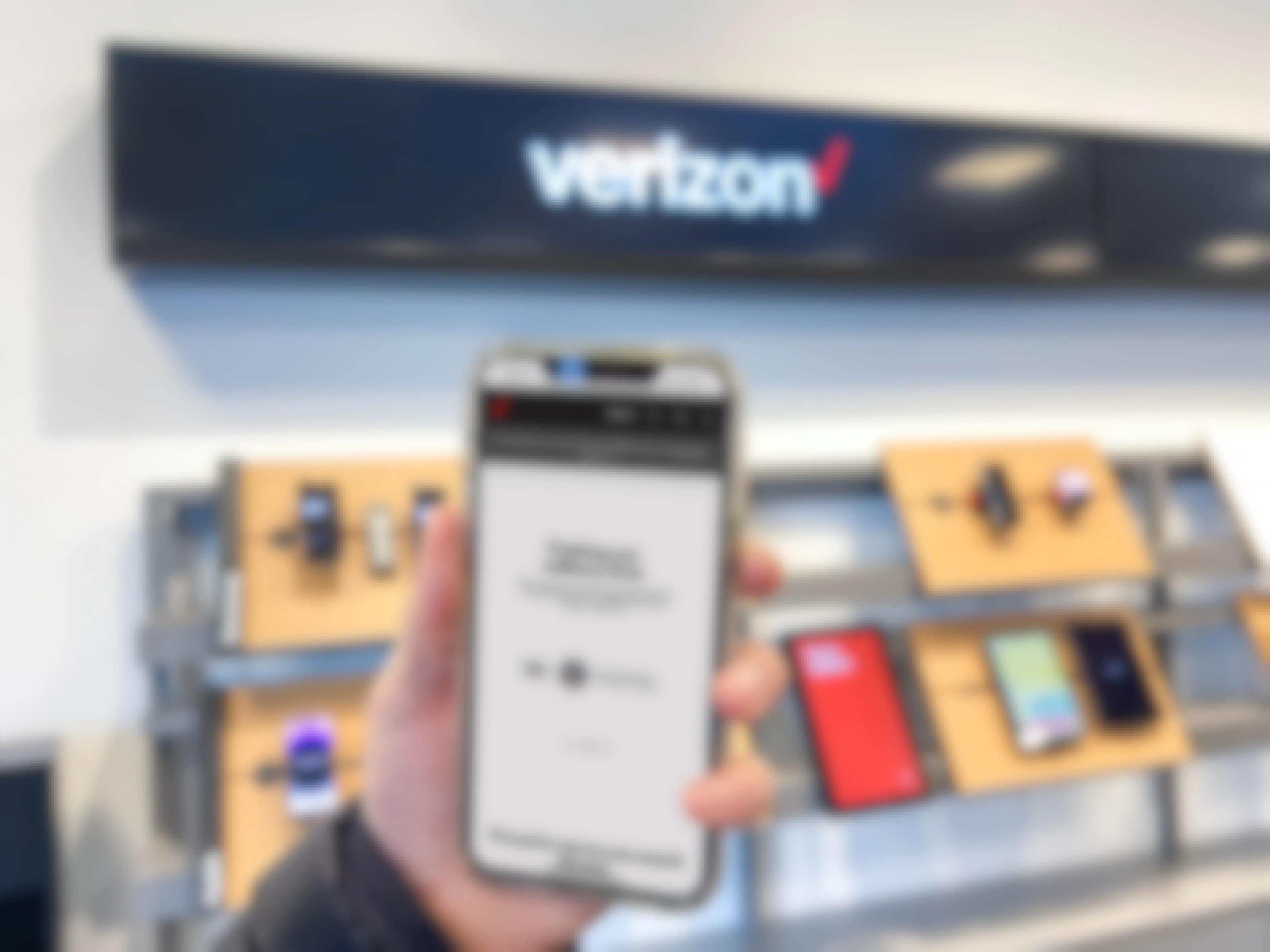 a hand holding a cellphone with military page on app in front of verizon sign 