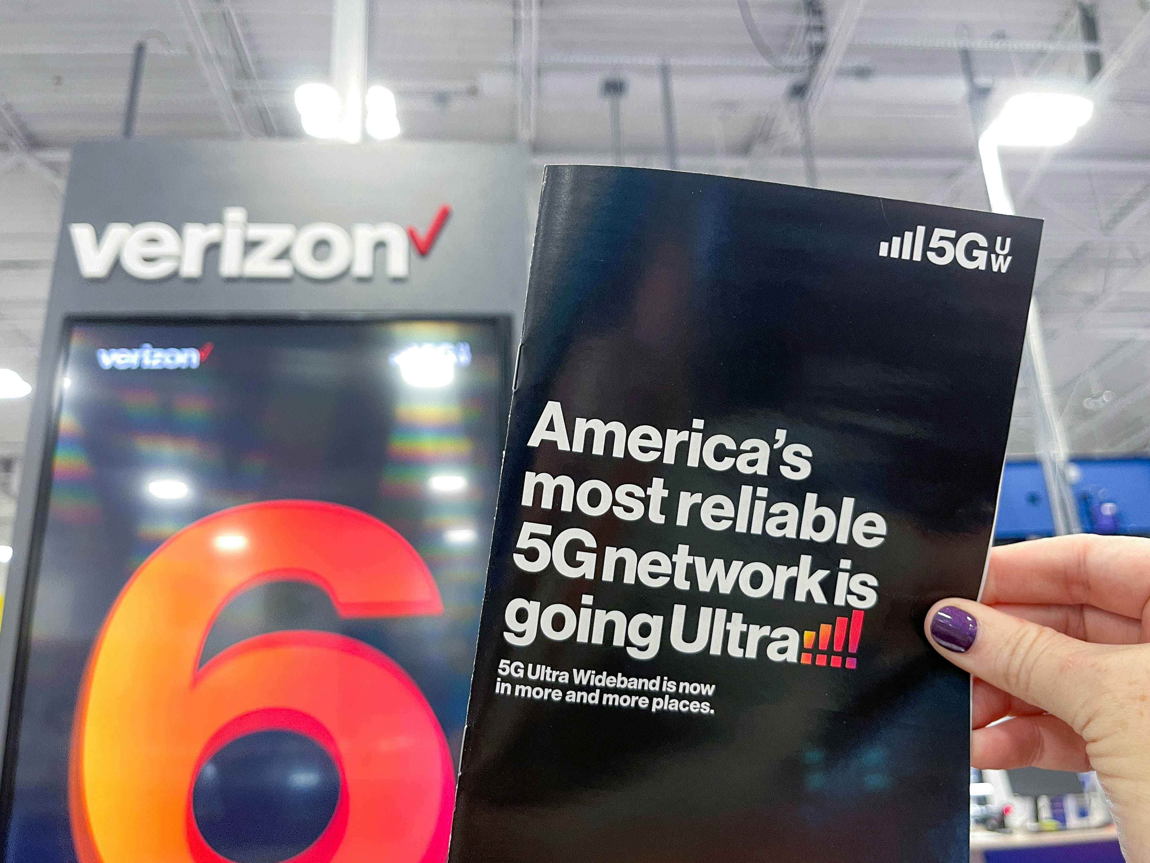 a person holding a verizon flyer in store