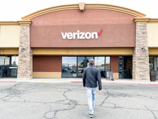 a person walking into outside a verizon store