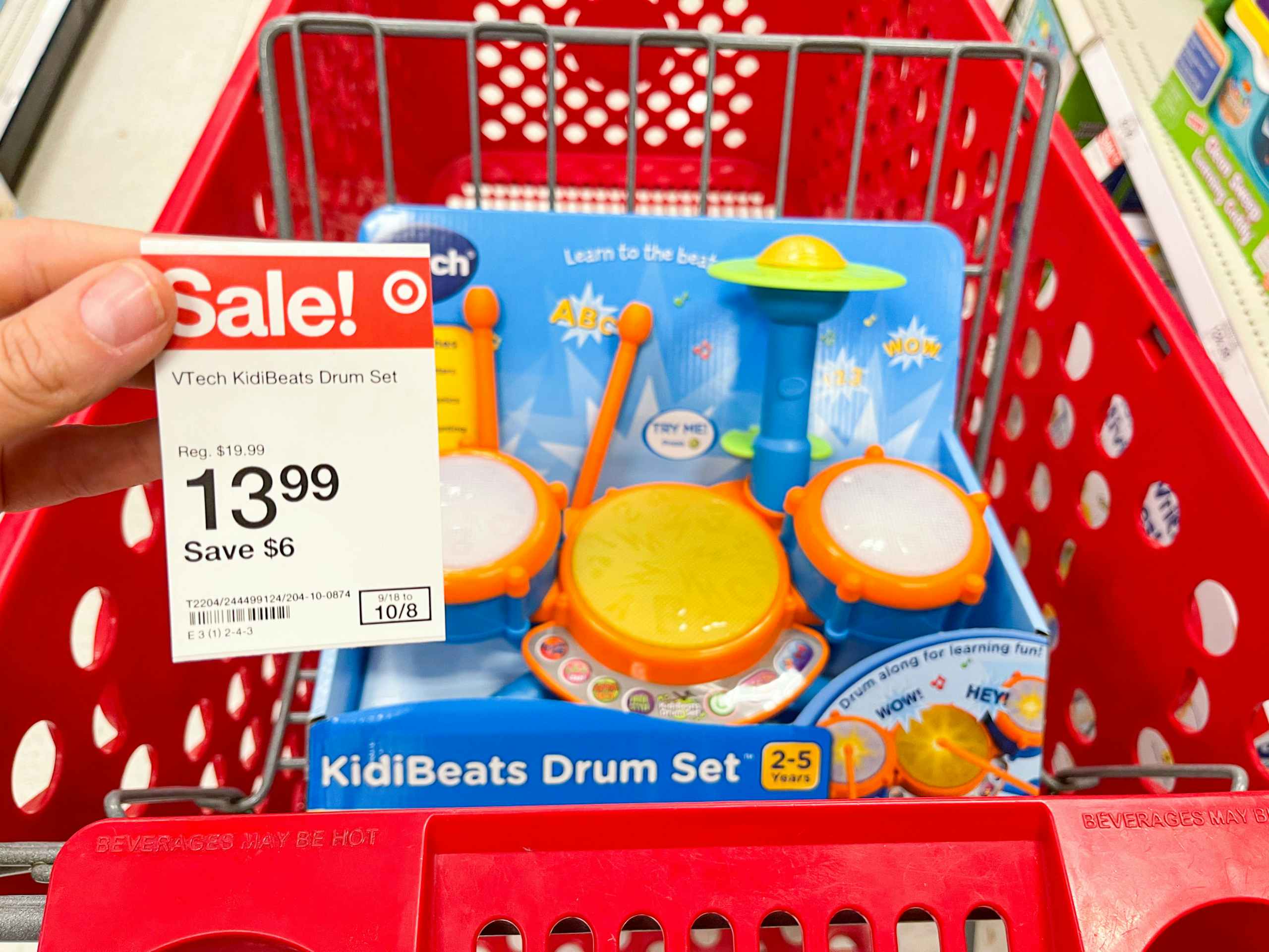 A VTech drum set sitting in a store cart