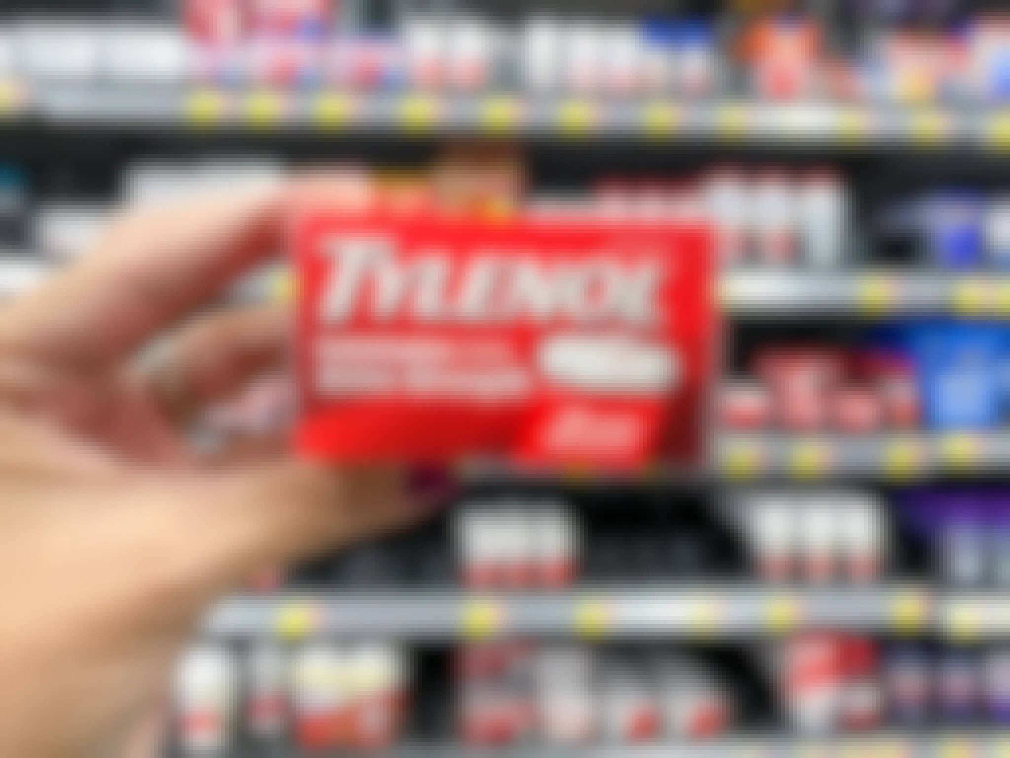 Someone holding up a box of Tylenol in a store