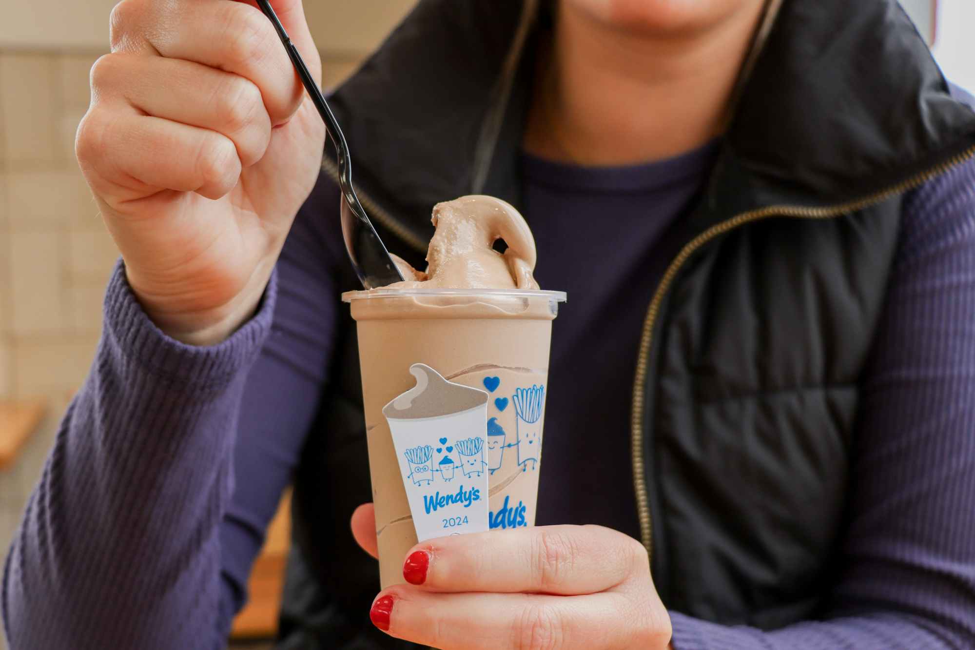 a person putting a wendys spoon into a frosty