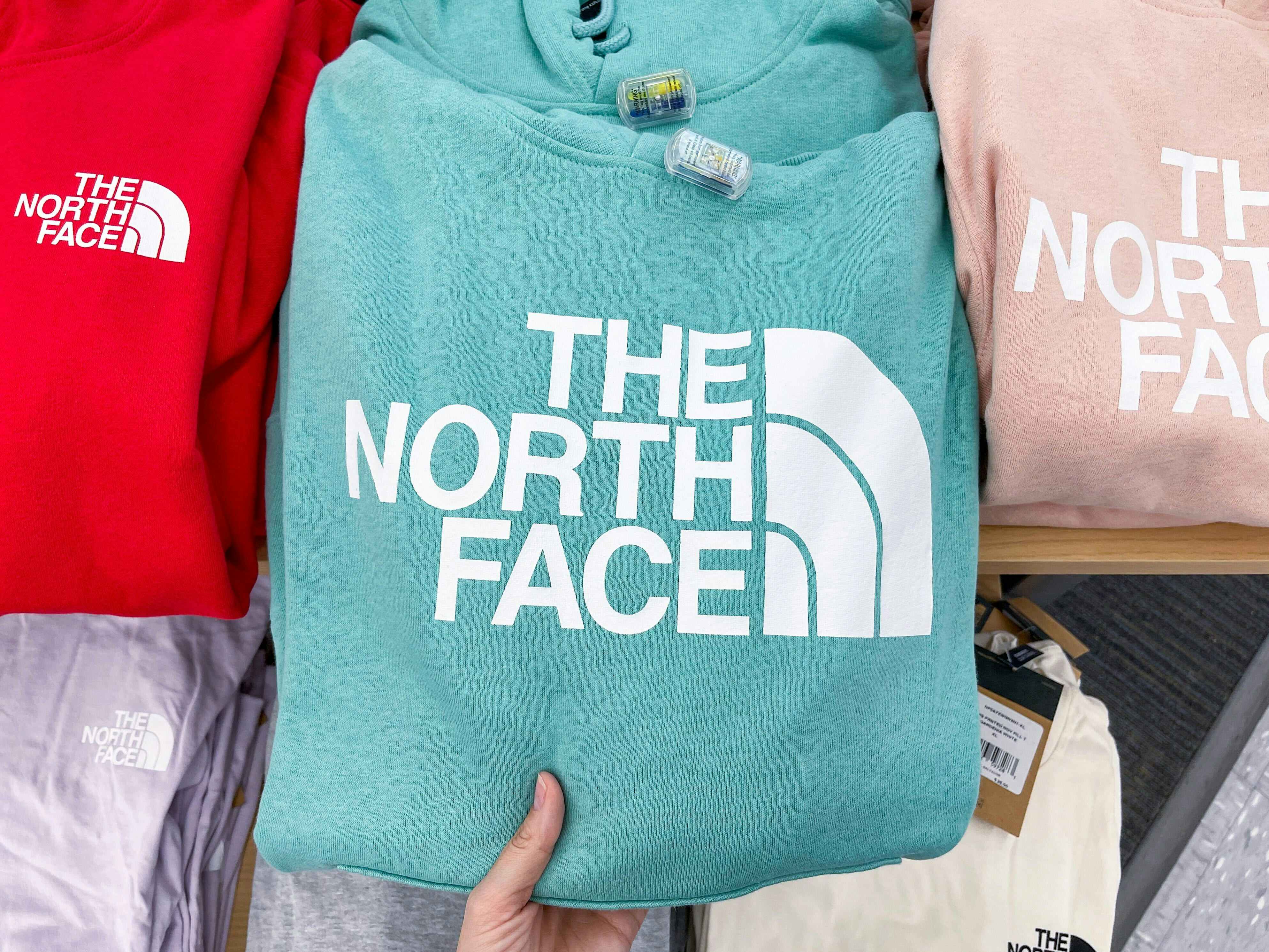 academy north face hoodies in store hand holding hoodie