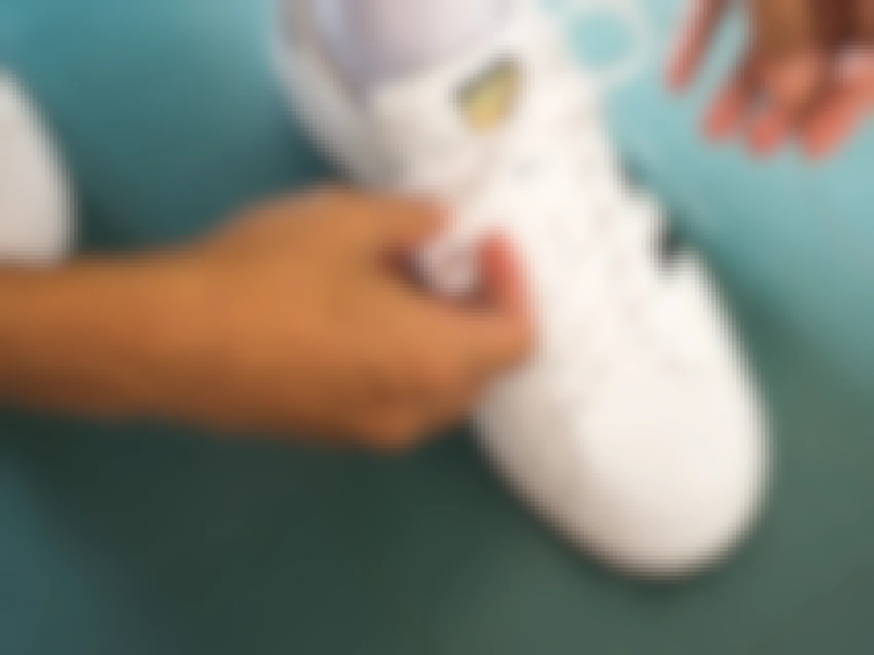 Person tying an adidas shoe