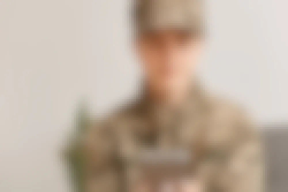 Person in military uniform looking at their phone